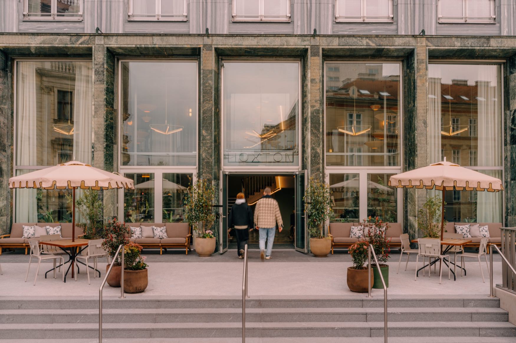 Entrance of the hotel, with seating area and parasol at the entrance.
